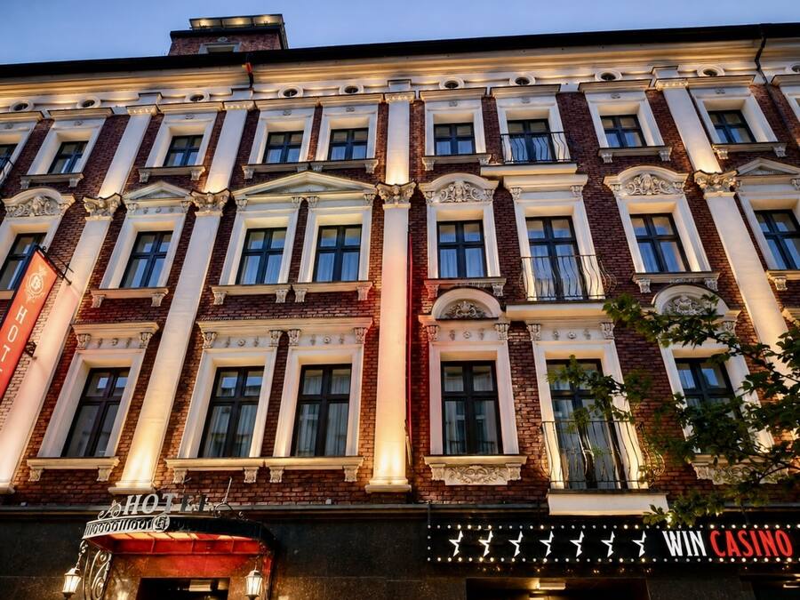 A hotel with a classic facade, large windows, and a casino sign.