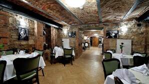 Un restaurante con paredes de ladrillo, pisos de madera y mesas preparadas para comer.