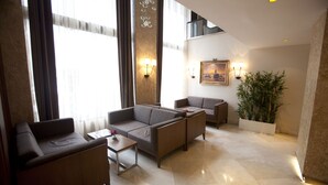 A modern hotel lobby with a seating area, large windows, and a potted plant. - Grand Laleli Hotel (Istanbul)