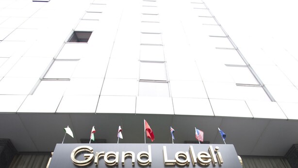 The Grand Laleh entrance with a geometric facade, a plaque, and flags. - Grand Laleli Hotel (Istanbul)