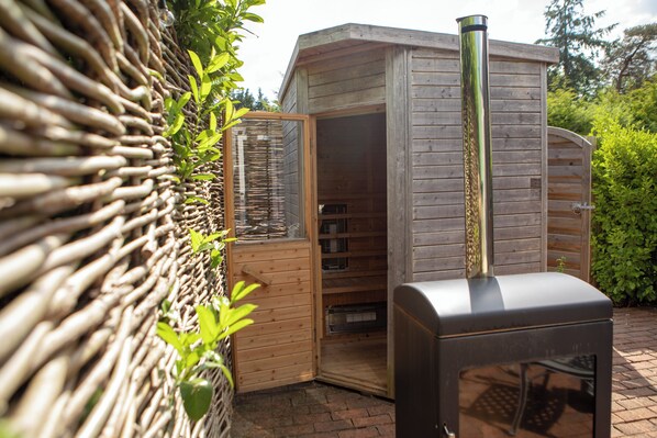 Une structure en bois dotée d’une cheminée, d’une porte et d’un petit espace clos avec des étagères.