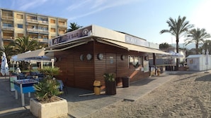 A snack bar named 'FLY'S SNACK BAR' with a wooden facade, outdoor seating, and a foosball table. - Hotel Internazionale (Finale Ligure)