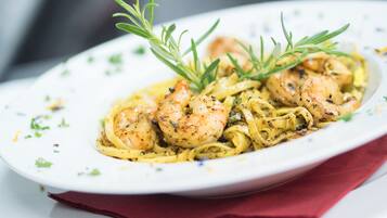 A plate of pasta with shrimp and rosemary garnish.