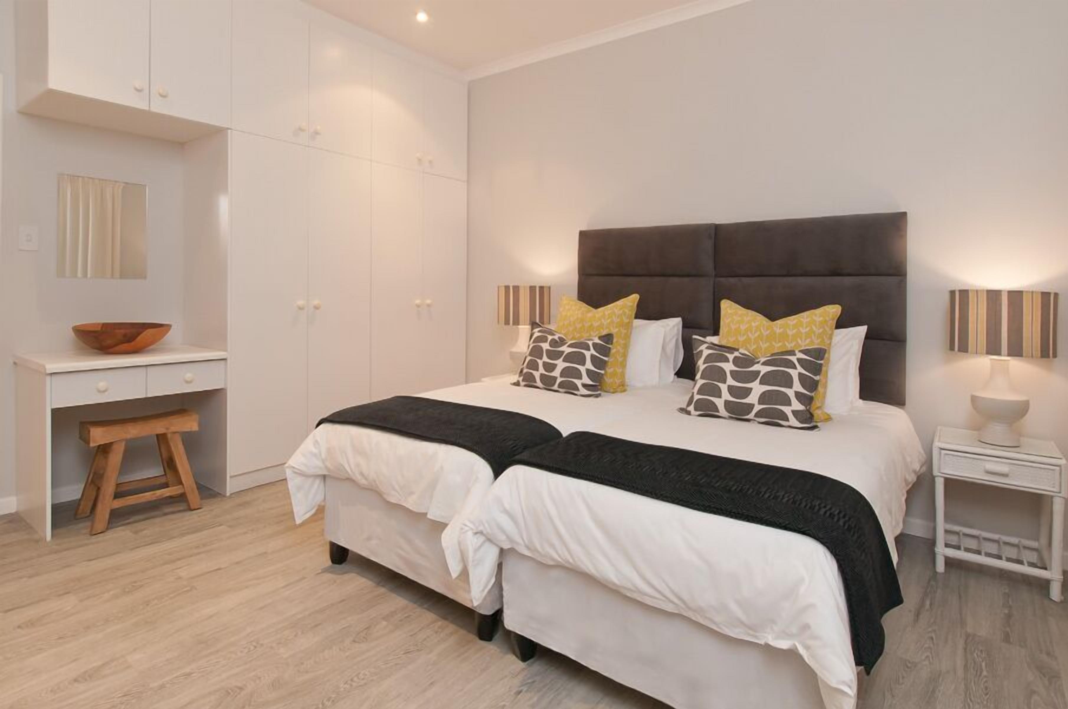 A bedroom with a bed, bedside tables, a desk, and a wardrobe.
