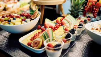 Una mesa de bufé con diversas opciones de fruta y postres.