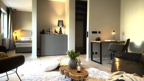 Ein modernes Wohnzimmer mit Sofa, Couchtisch und Essbereich mit Tisch und Stühlen.