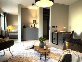 A modern living room with a sofa, a coffee table, and a dining area with a table and chairs.