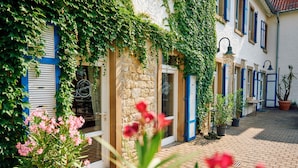 Ein Innenhof mit einer Steinmauer, Kübelpflanzen und einem Blumenbeet.
