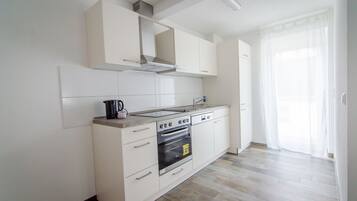 Apartamento Deluxe, balcón | Cocina privada | Frigorífico, microondas, horno y placa de cocina