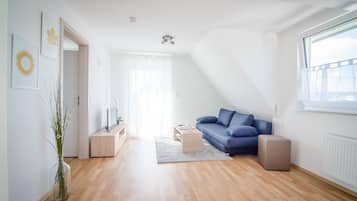 Apartamento Deluxe, balcón | Zona de estar | Una televisión de pantalla plana