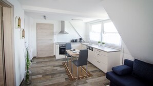 A compact kitchen with a dining area, a built-in stove, and a window providing natural light. - BB-Apartment (Boeblingen)