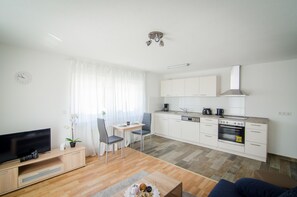 Apartamento Deluxe | Zona de estar | Una televisión de pantalla plana