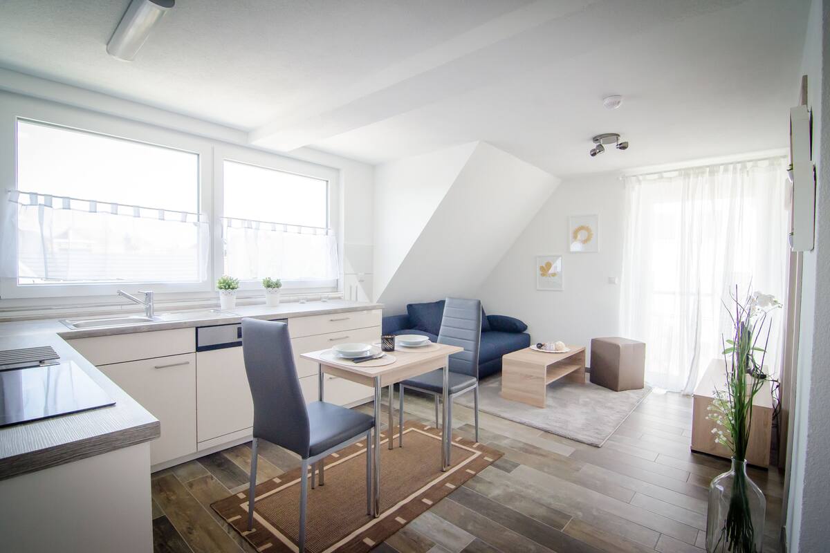 Una cocina moderna con comedor, sofá y una pequeña mesa.