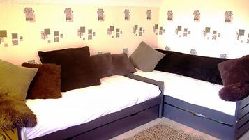 Ein Zimmer mit einem Bett, einem kleinen Schreibtisch und einer Wand mit Geschenkkarton-Dekorationen.
