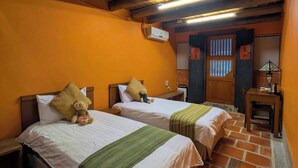 Una habitación con dos camas, techo de madera, paredes color naranja y suelo de baldosas.