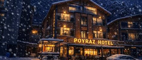 A hotel with a sign reading 'POYRAZ HOTEL' in a snowy setting.