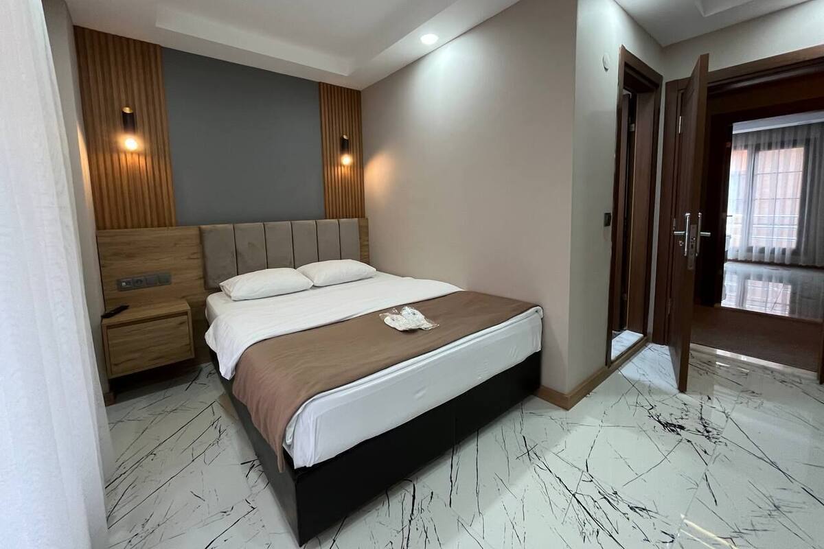 A modern bedroom with a bed, nightstand, and a wardrobe.