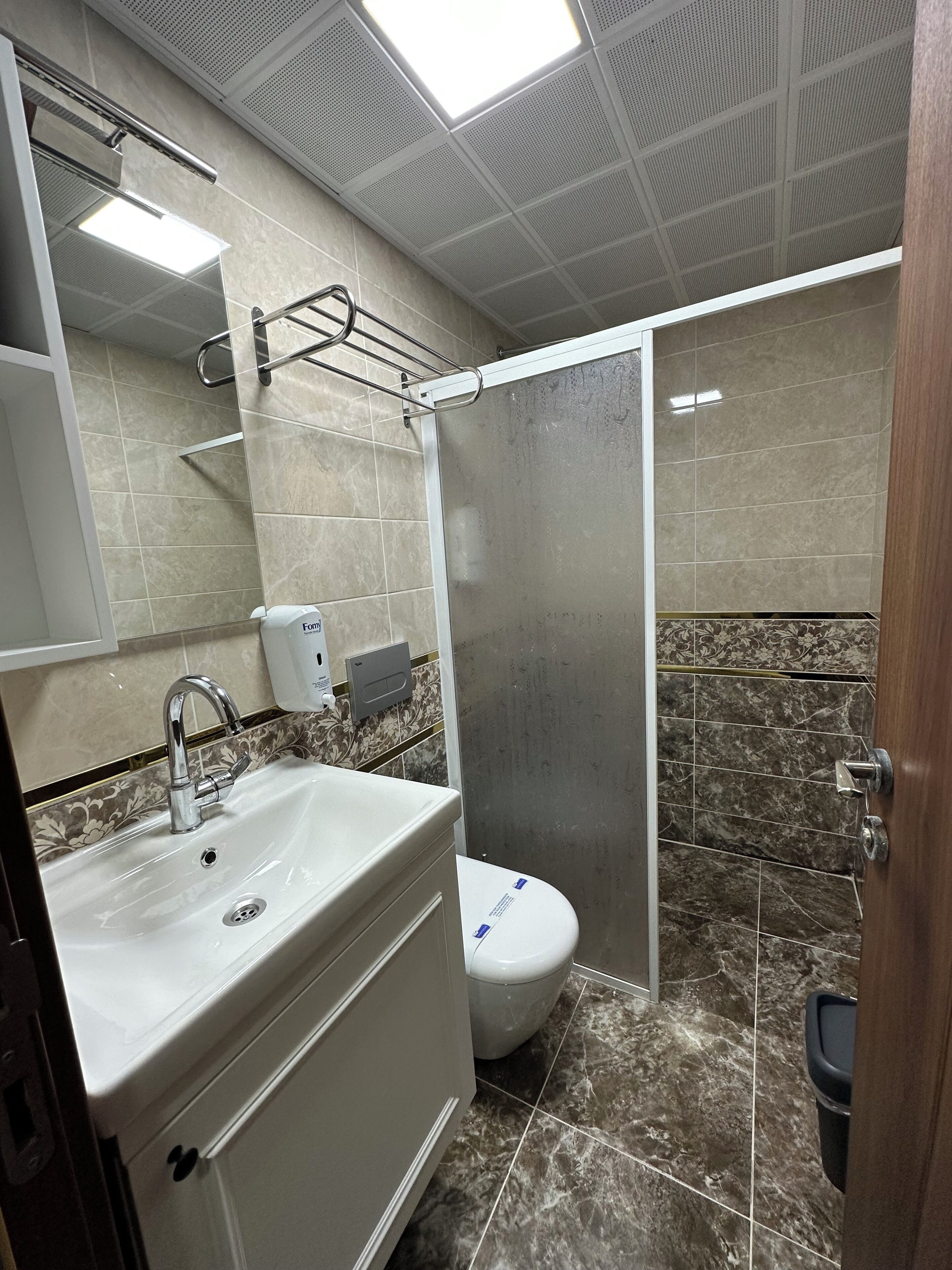 A bathroom with a sink, toilet, and shower area.