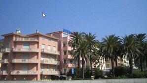 Un hotel de varios pisos, con balcones y un cielo azul despejado.