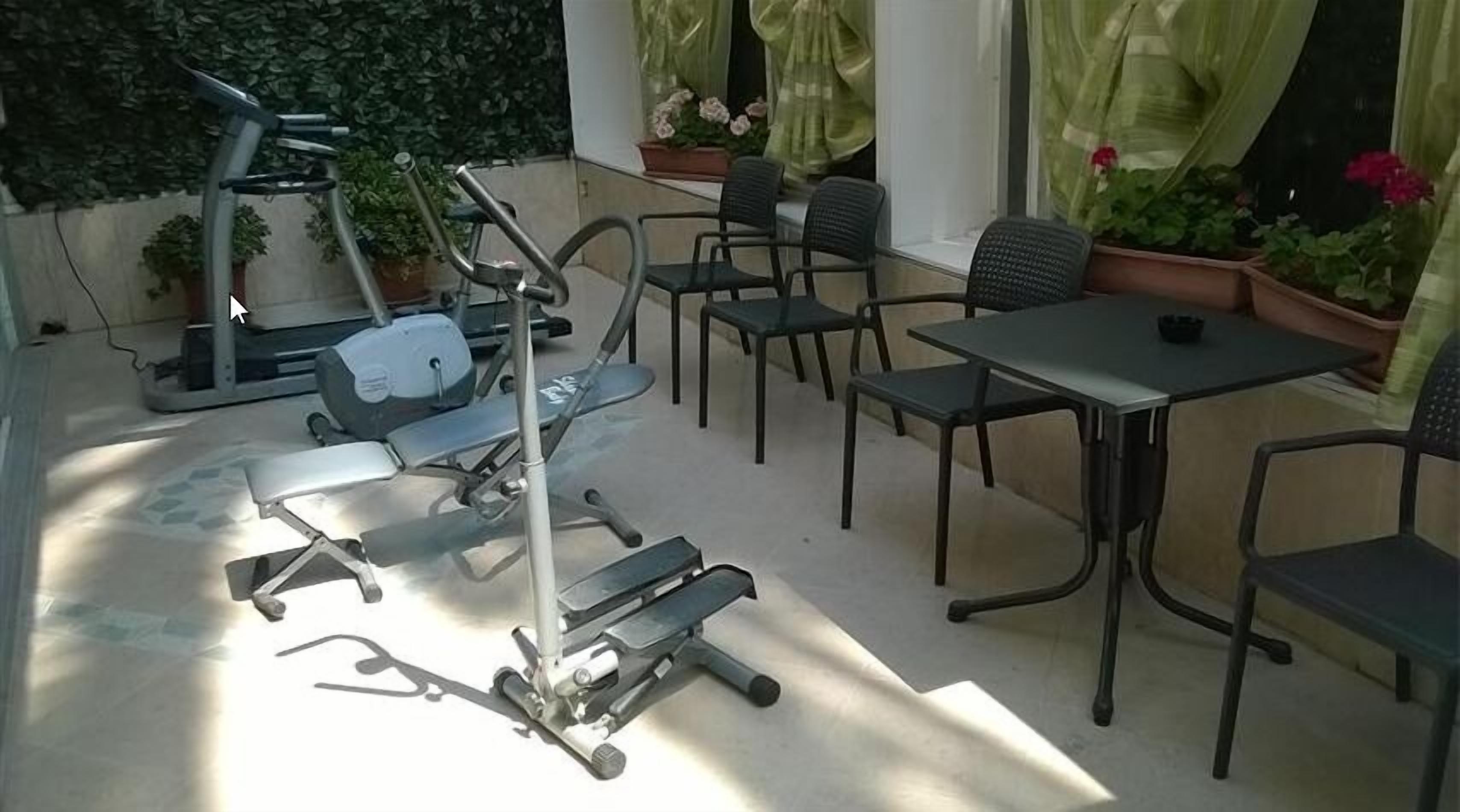 Un'area patio con attrezzature per esercizi, un tavolo e sedie.