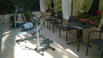 Un'area patio con attrezzature per esercizi, un tavolo e sedie.