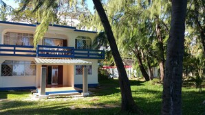 A two-story building with a blue and white facade, a covered entrance, and a small porch area. - Ariambello Vacation (Riambel)