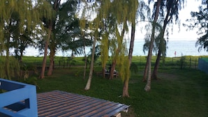 A grassy area with trees and a view of the sea. - Ariambello Vacation (Riambel)