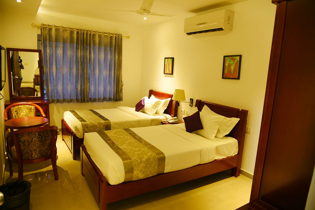 twin cot room with attached bathroom | premium bedding, in-room safe, desk, soundproofing