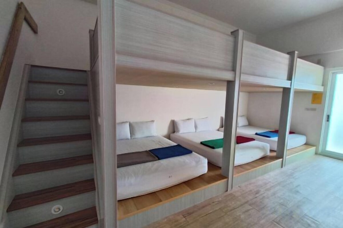 A bunk bed room with a staircase on the left.
