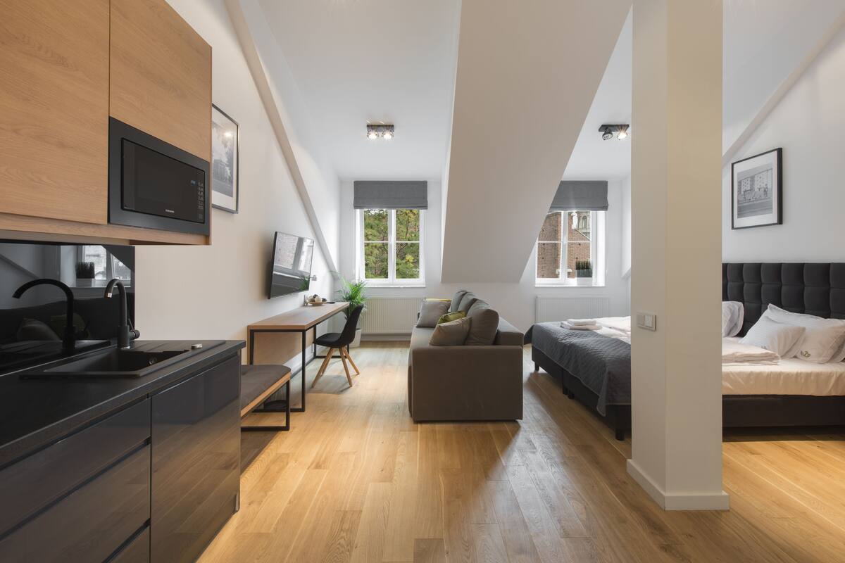 A modern apartment with a kitchen, dining area, and a bedroom.