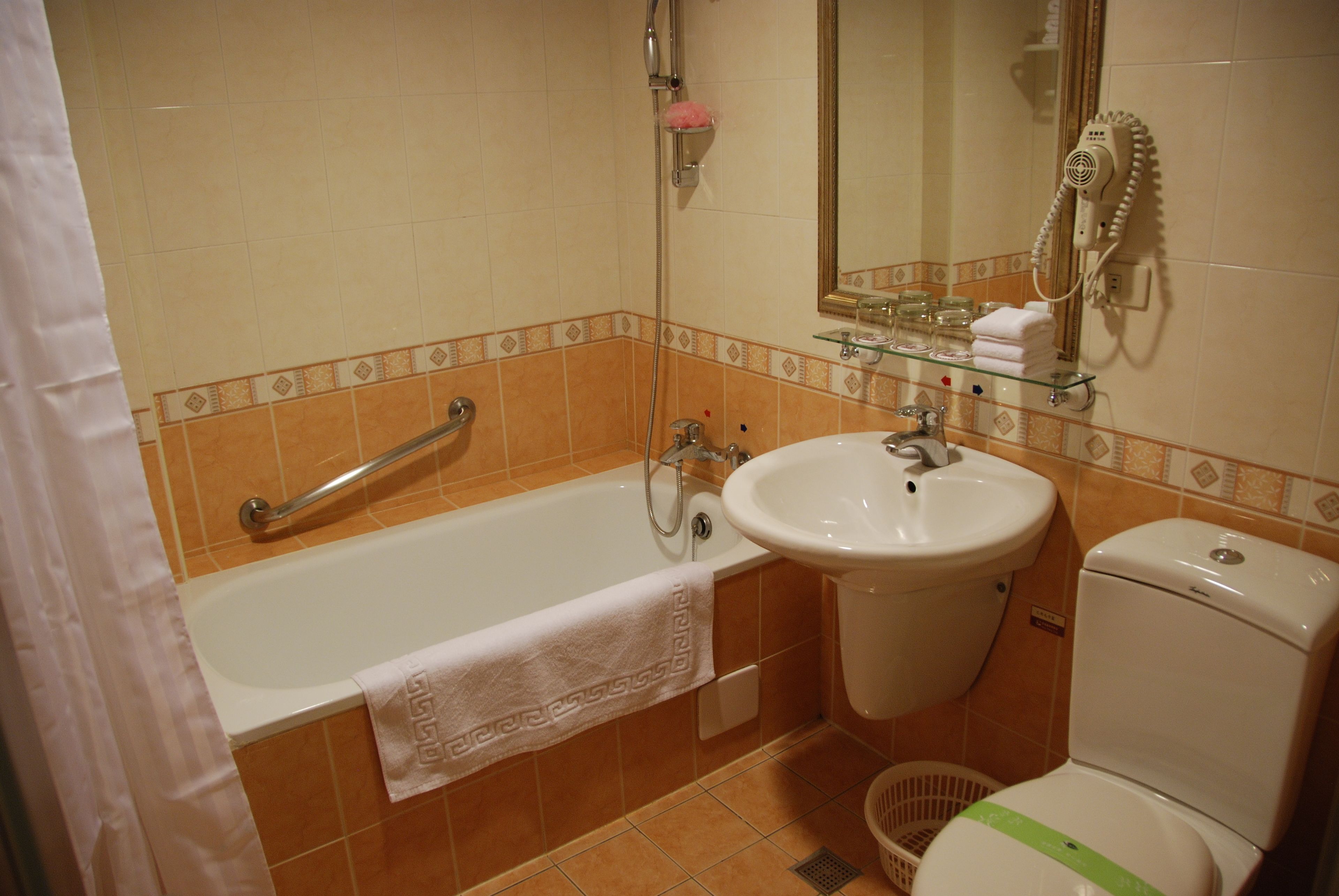Un baño con bañera, lavamanos e inodoro.