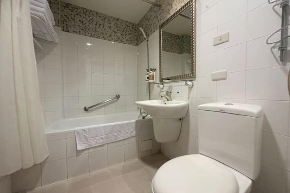 A bathroom with a bathtub, toilet, sink, and a shower.