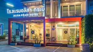 Exterior del Hotel Alisa Krabi, con un letrero visible, entrada techada y zona de estar al aire libre.