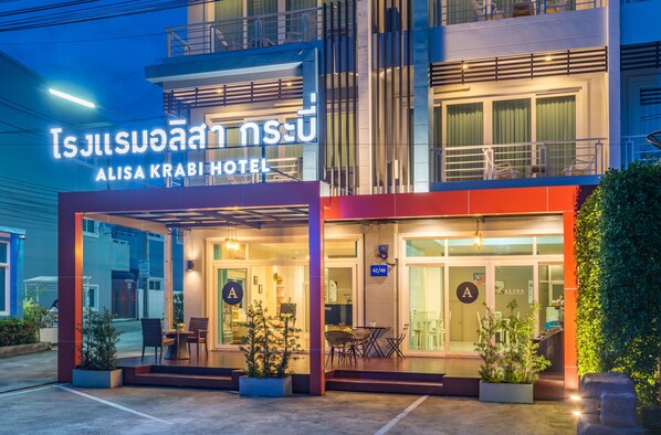 The exterior of Alisa Krabi Hotel with a clear sign, a covered entrance, and outdoor seating area. - Alisa Krabi Hotel (Krabi)
