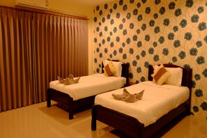 A hotel room with two beds, a large window with curtains, and a floral wallpaper pattern. - Alisa Krabi Hotel (Krabi)