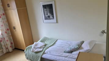 Une chambre à coucher avec un lit, une armoire, un tableau encadré et une table de chevet.