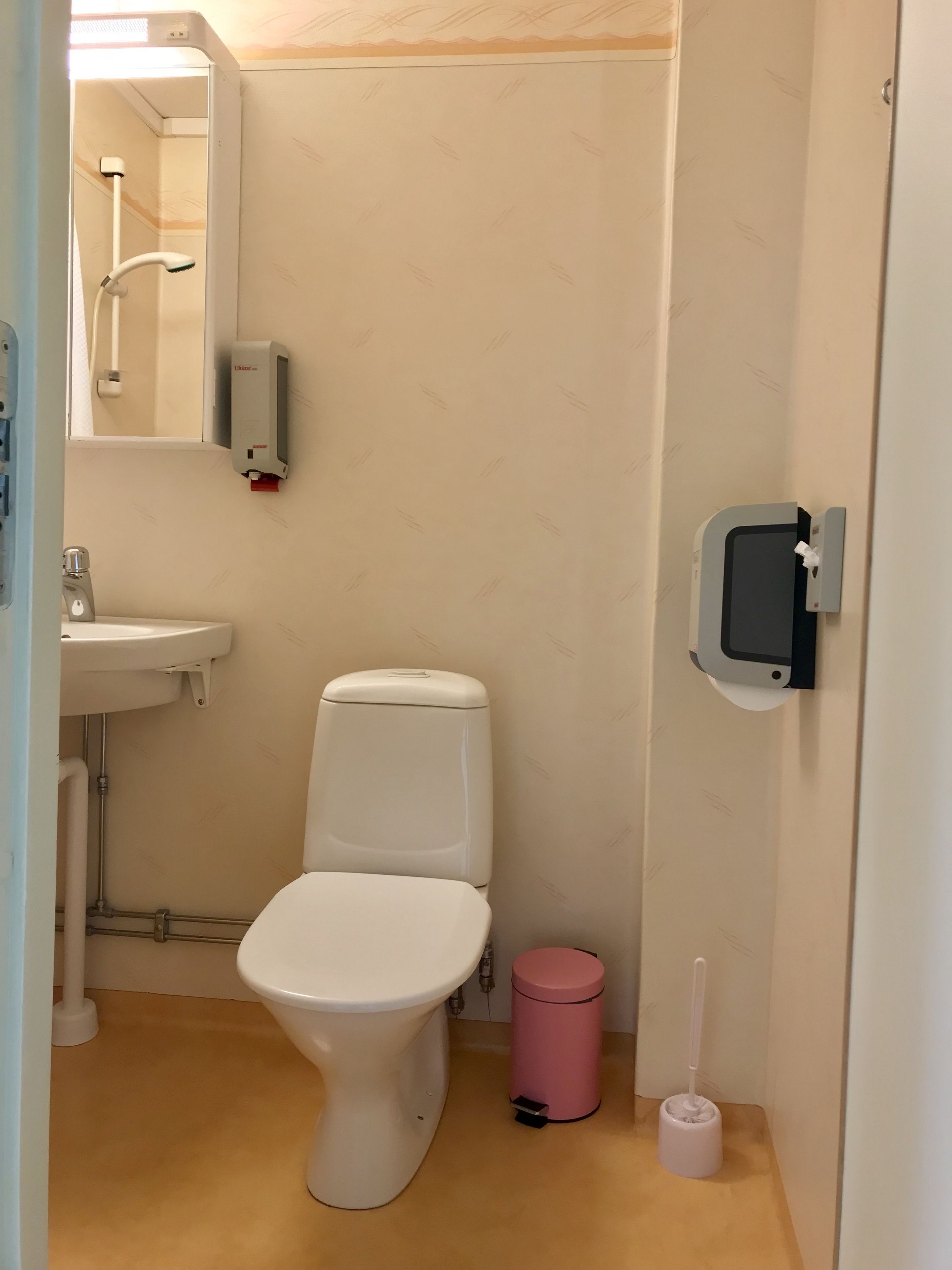 Un bagno piccolo e pulito con il water, un lavandino e un asciugamani ad aria.