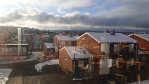 Un quartier résidentiel avec des maisons en briques, dont certaines sont recouvertes de neige, et un ciel nuageux.
