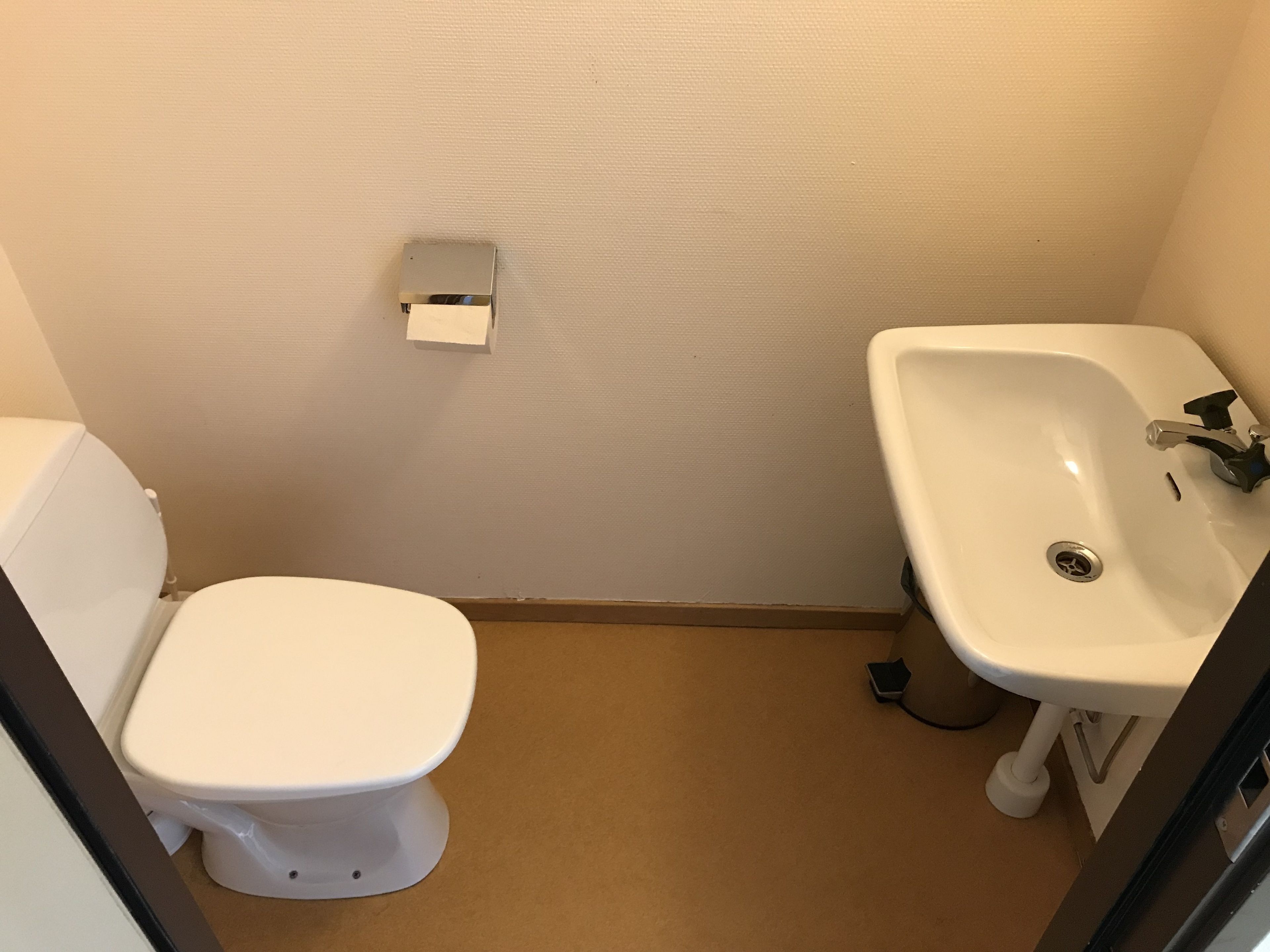 A small bathroom with a toilet and a sink.