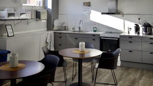 Une cuisine moderne avec un coin repas, équipée d’un four à micro-ondes, d’un évier et d’une cuisinière.