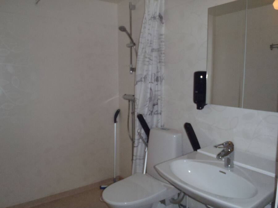 Une salle de bain avec des toilettes, un lavabo et une douche.
