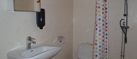 A bathroom with a sink, toilet, and shower.