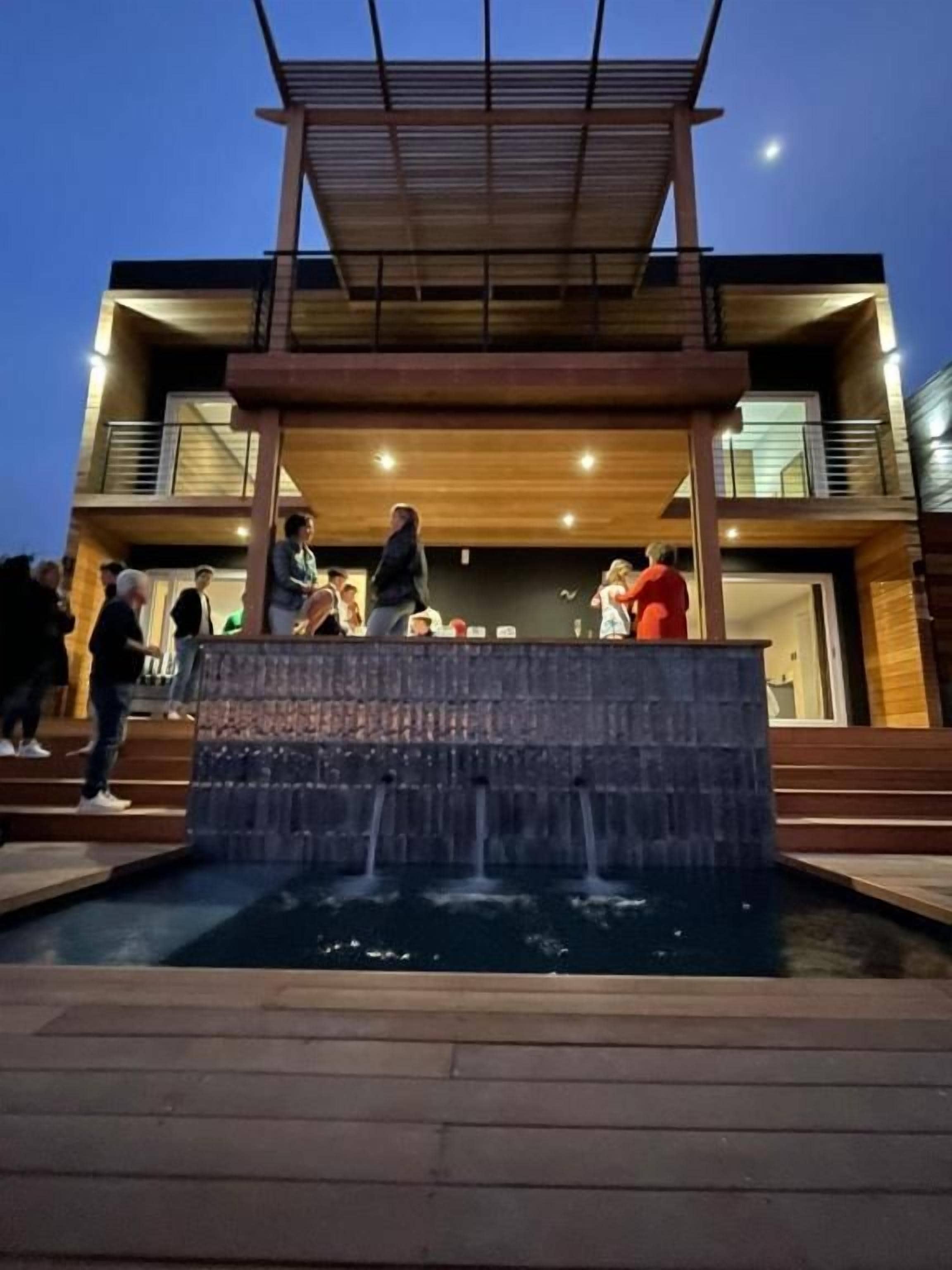 A modern building with a pool and outdoor seating area.