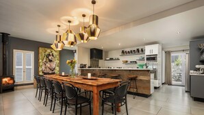 Una cucina moderna con isola centrale, illuminazione a sospensione e zona pranzo con sedie.