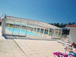 Una piscina cubierta, una piscina al aire libre, tumbonas
