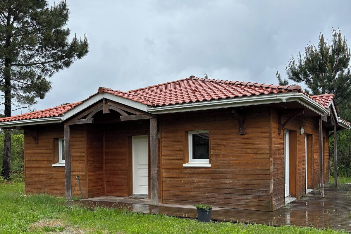Una cabana de fusta amb teulada vermella, un porxo i una petita finestra frontal.