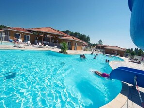 Una piscina cubierta, una piscina al aire libre, tumbonas