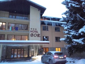 A hotel with a sign reading "HOTEL BOR" and a car parked in front. - Bor Hotel (Borovets)