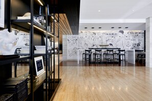 A modern interior with a wooden floor, black shelving units, and a large wall mural.