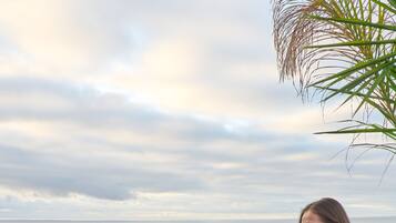 Two people dining at an outdoor table with a view of the sea.